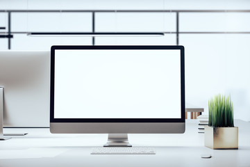 Computer on contemporary designer workplace with white screen