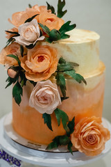 Vertical images of beautiful modern wedding cake decorated with pink flowers. Party and holiday celebration concept