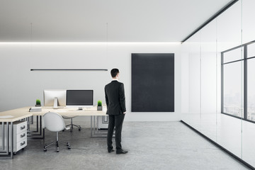 Businessman standing in office room with computers