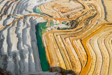 Top view on a stone quarry. Arial view on a mining of natural resources or ore. Green river...