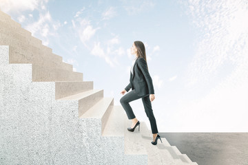 Young businesswoman climbing abstract stairs