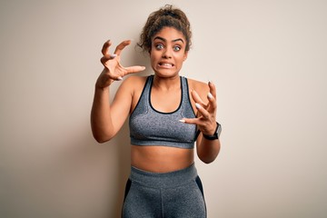 Young african american sportswoman doing sport wearing sportswear over white background Shouting frustrated with rage, hands trying to strangle, yelling mad