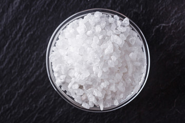 coarse sea salt on a dark stone background