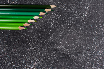 Green pencils on a black stone table