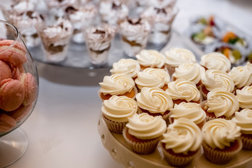 Sweet table for birthday or wedding ceremony. Candy bar with a lot of different candies and sweet cakes. Selective focus. Party and holiday celebration concept