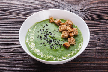 broccoli spinach cream soup on rustic wooden background