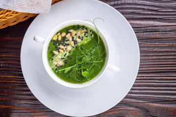 broccoli spinach cream soup on rustic wooden background