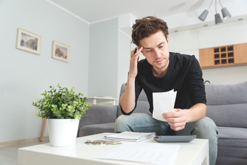 Man holding receipt, making financial revision