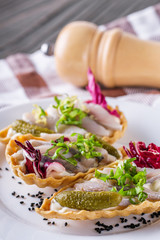 delicious snack tartlets on rustic wooden background