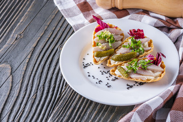 delicious snack tartlets on rustic wooden background
