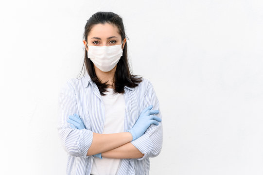 Portrait Of A Woman Doctor Or Nurse In A Protective Mask And In Medical Gloves On A White Background