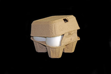 Salted eggs in recycled paper carton packaging on black background.