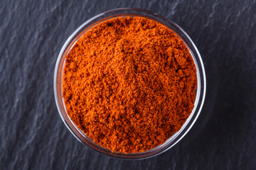 aromatic spicy chilli powder on a dark stone background