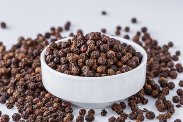 fragrant black pepper on white acrylic background