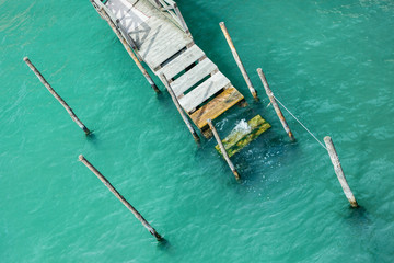 Wooden pier in Venice for boats. View from above. Against the background of azure water.