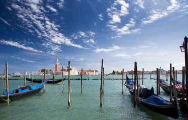 Gondolas are at the pier in Venice, overlooking the Church of San Giorgio Maggiore.