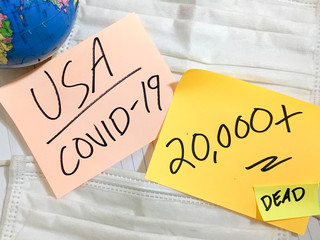 USA Coronavirus COVID-19 infection medical cases and deaths United States. China COVID respiratory disease influenza virus statistics hand written on surgical mask and earth globe background.