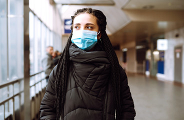 Girl in protective sterile medical mask on her face in quarantine city. Woman, wear face mask,...