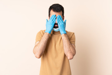 Caucasian man with beard protecting from the coronavirus with a mask and gloves over isolated...