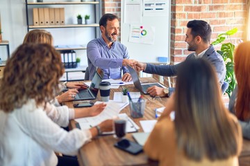 Obraz premium Group of business workers smiling happy and confident. Working together with smile on face shaking hands at the office