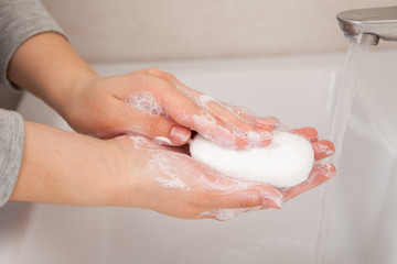 Fototapeta premium closeup soaped female hands holding a bar of soap. holding for 20 seconds to completely destroy the virus on the hands