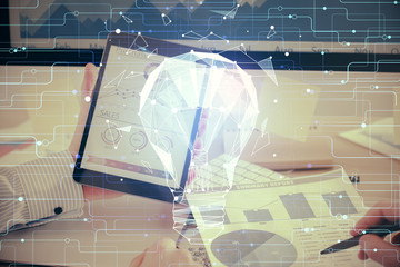 Double exposure of man's hands holding and using a digital device and bulb hologram drawing. Idea concept.