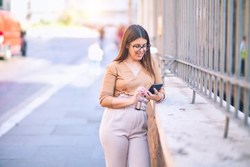 Young beautiful woman smiling happy and confident. Standing with smile on face using smartphone at the city