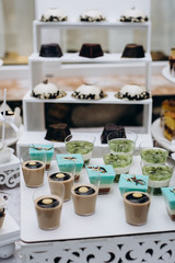 Close up of sweet table for wedding ceremony or birthday . Candy bar with a lot of different candies and sweet cakes. Selective focus. Party and holiday celebration concept