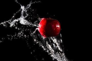 The water is splashed apple  on the  until the water is distributed beautifully on a black background.