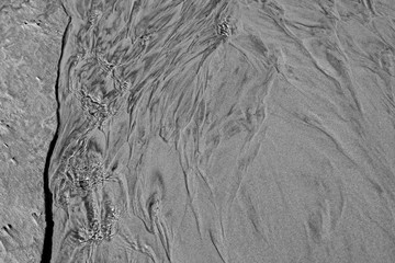 Laesoe / Denmark: Reflections on the water surface of a very shallow rivulet on the beach at Storedal in the north-west of the island