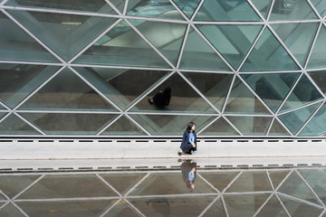 Young business women passing through glass buildings