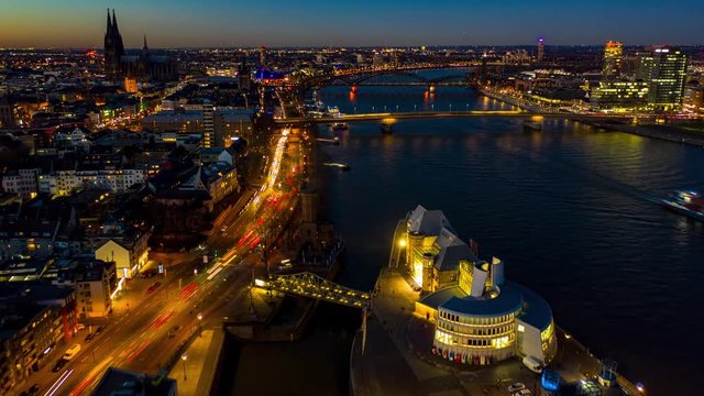 Urban night timelapse of Cologne with illuminated streets and buildings
