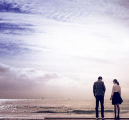 20s' couple walking on the beach at sunset