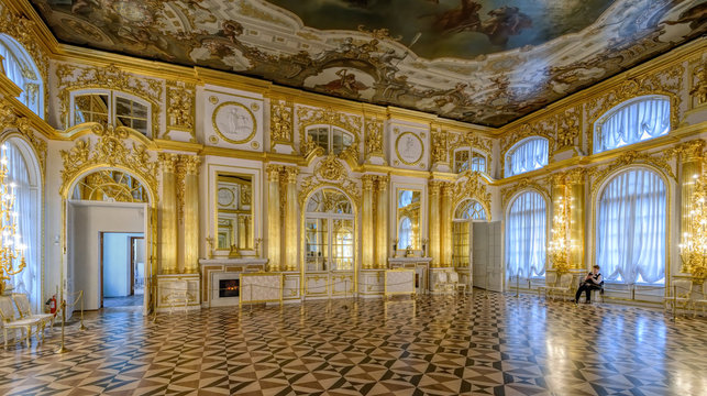 Ornate interior of the Catherine Palace. Third Antechamber decorated by fluted columns, marble fireplaces and three-dimensional sculpture, cartouches and garlands, St. Petersburg, Russia.