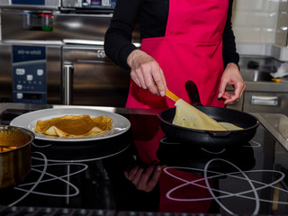The process of making pancakes. Cook in the kitchen makes the dough