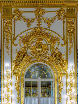 Magnificent carved baroque decor, candlesticks, mirrors, sculptural and ornamental gilded carvings covering the walls of the Catherine Palace of Tsarskoe Selo. Saint-Petersburg, Russia.