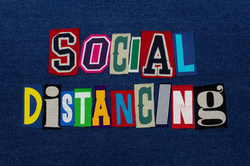 SOCIAL DISTANCING Coronavirus COVID-19 symptom, text word collage, worldwide pandemic flu virus containment, colorful letters on blue denim, horizontal aspect