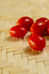 vertical photo of red tasty cherry tomatoes appetizing close-up vegetable set on wooden background