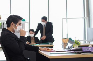 Business workers wear masks to protect and take care of their health.young asia  business man feeeling sick in work office
