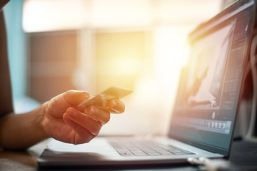 Hand with credit card with laptop shopping online concept.