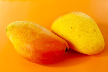 Mango isolated on orange background close up fruit