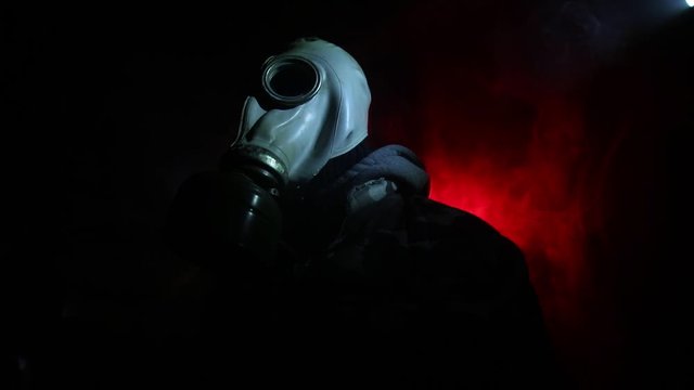 Environmental disaster. Post-apocalyptic survivor in gas mask on a dark background. Dramatic portrait of a man wearing a gas mask. Means for radiation protection. Selective focus