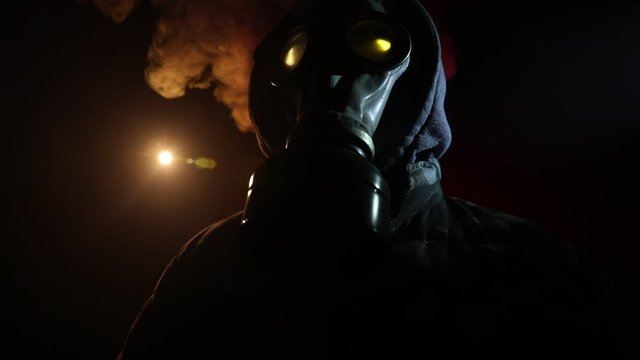 Environmental disaster. Post-apocalyptic survivor in gas mask on a dark background. Dramatic portrait of a man wearing a gas mask. Means for radiation protection. Selective focus