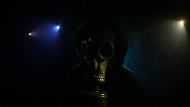 Environmental disaster. Post-apocalyptic survivor in gas mask on a dark background. Dramatic portrait of a man wearing a gas mask. Means for radiation protection. Selective focus