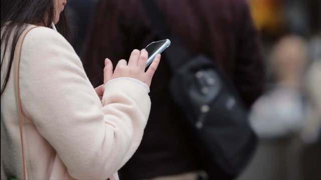 スマホを操作する若い女性の手元