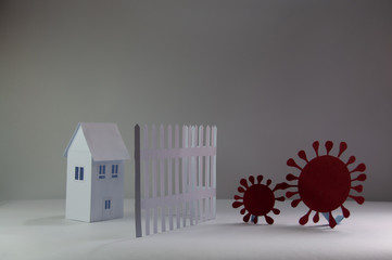 Representations of coronavirus COVID 19 made from paper trying to enter quarantined houses