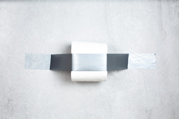 Roll of toilet paper fixed with gray adhesive tape