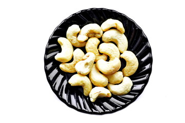 Cashew nut arranged in black dishes isolated on white background. Top view