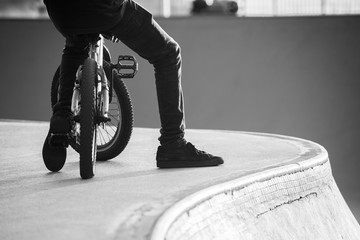 BMX cyclist resting next to a black and white photography ramp