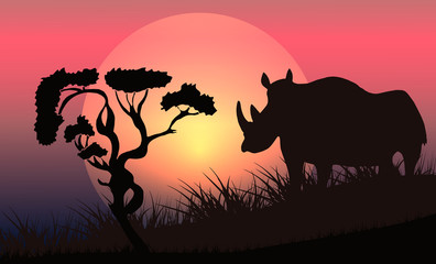 Vector illustration of a black silhouette of a rhino on the grass with a tree on a background of sunrise.